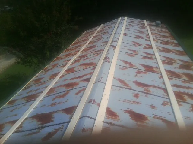 Rusted metal roof panels with new wood purlins before replacement — Storm Damage Roof Repair in Cohasset by Roofing Brothers